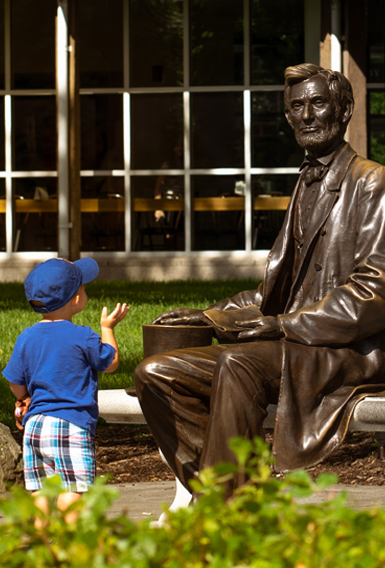 A young visitor greets the statue of Abraham Lincoln at the Gettysburg National Military Park Museum and Visitor Center